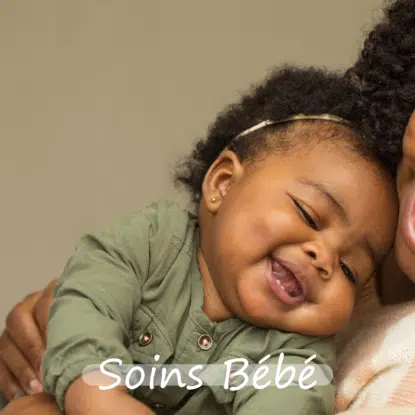 Un bébé souriant aux cheveux bouclés, vêtu d'un ensemble vert et d'un bandeau, est câliné par un adulte. Le texte "Soins Bébé" et la marque Univers Cosmetix figurent en bas de l'image. Dakar