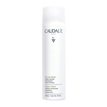 Un flacon cylindrique blanc d'eau de raisin Caudalie, avec un texte et un logo minimalistes en noir et vert, avec un embout de pulvérisation et un poids net de 300 ml (10,7 oz). Dakar