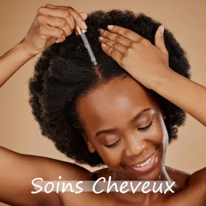 Une femme souriante applique le sérum capillaire Univers Cosmetix sur son cuir chevelu à l'aide d'un compte-gouttes. Elle a des cheveux naturels et bouclés et pose sur un fond beige. Le texte "Soins Cheveux" apparaît en bas de l'image. Dakar