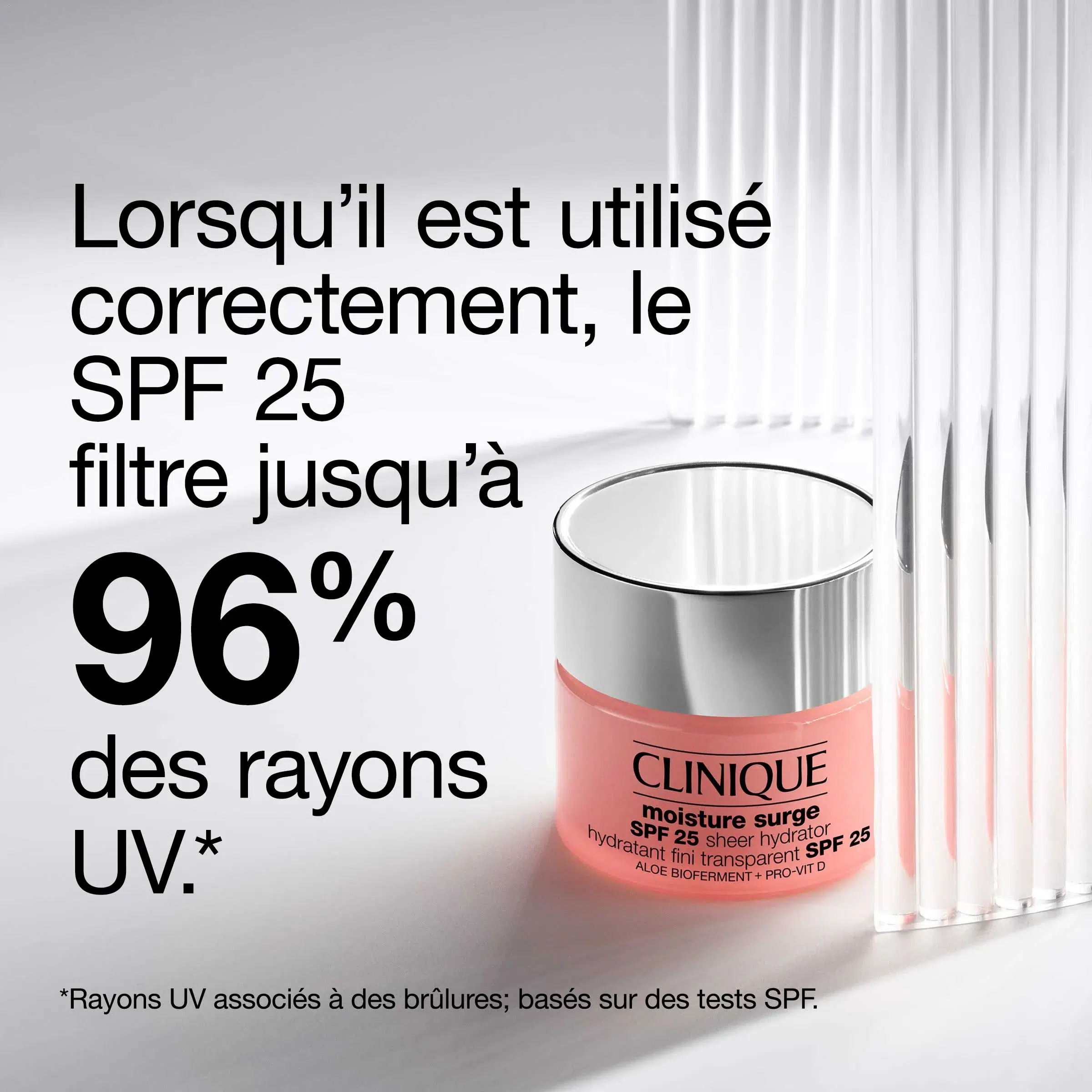 Un pot de crème hydratante Clinique Moisture Surge SPF 25 est présenté avec des baguettes en verre à côté. Le texte en français indique que le SPF 25 filtre jusqu'à 96 % des rayons UV lorsqu'il est utilisé correctement. Une note de bas de page sur les tests SPF est incluse. Dakar