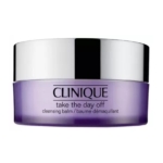 Un pot violet avec un couvercle argenté étiqueté "Clinique Take the Day Off cleansing balm / baume démaquillant" sur un fond blanc. Dakar
