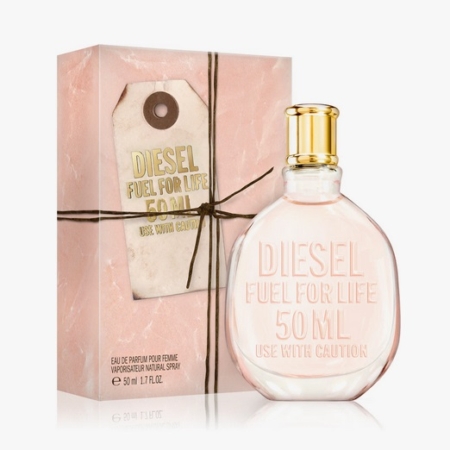 Un flacon de 50 ml de Fuel for Life Eau de Parfum pour femme avec un design rose et or se trouve devant sa boîte rose et or assortie, qui comporte une étiquette graphique et un cordon noir. Dakar