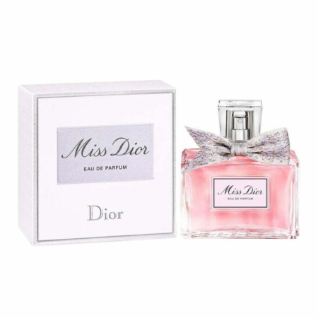 Un flacon de 50 ml de Dior Miss Eau de Parfum Vaporisateur avec un liquide rose et un nœud est présenté à côté de sa boîte blanche et argentée portant les logos "Miss Dior" et "Dior". Dakar
