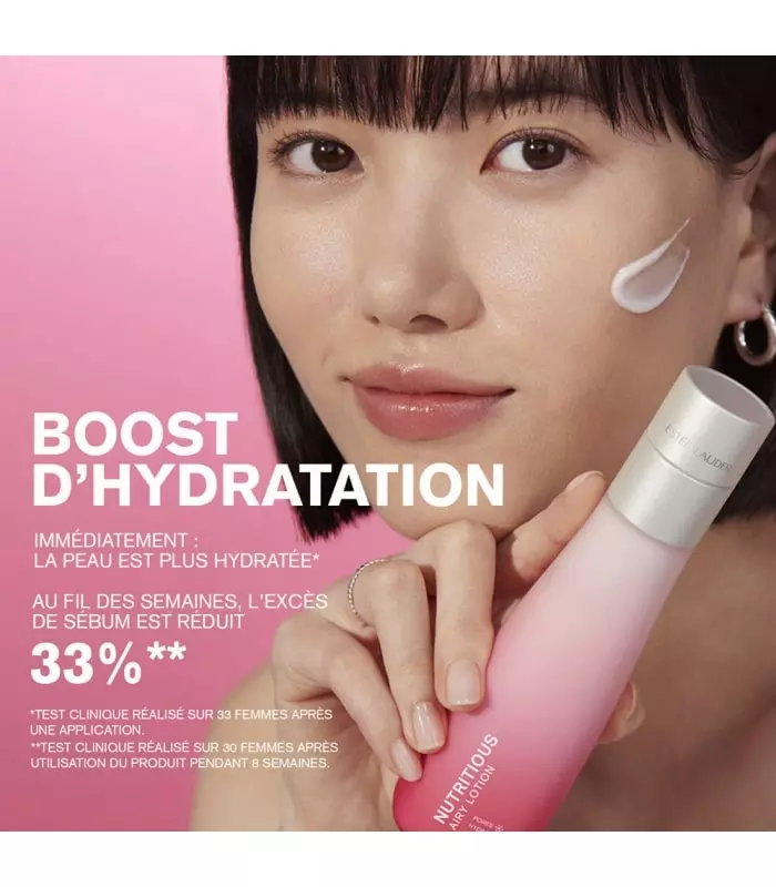 Une femme aux cheveux courts et bruns sourit en tenant Estée Lauder Essence Émulsion Hydratante Légère Nutritious Radiant 200ml. Une noisette de crème est posée sur sa joue tandis que le texte français souligne l'hydratation et la réduction de 33 % du sébum. Dakar