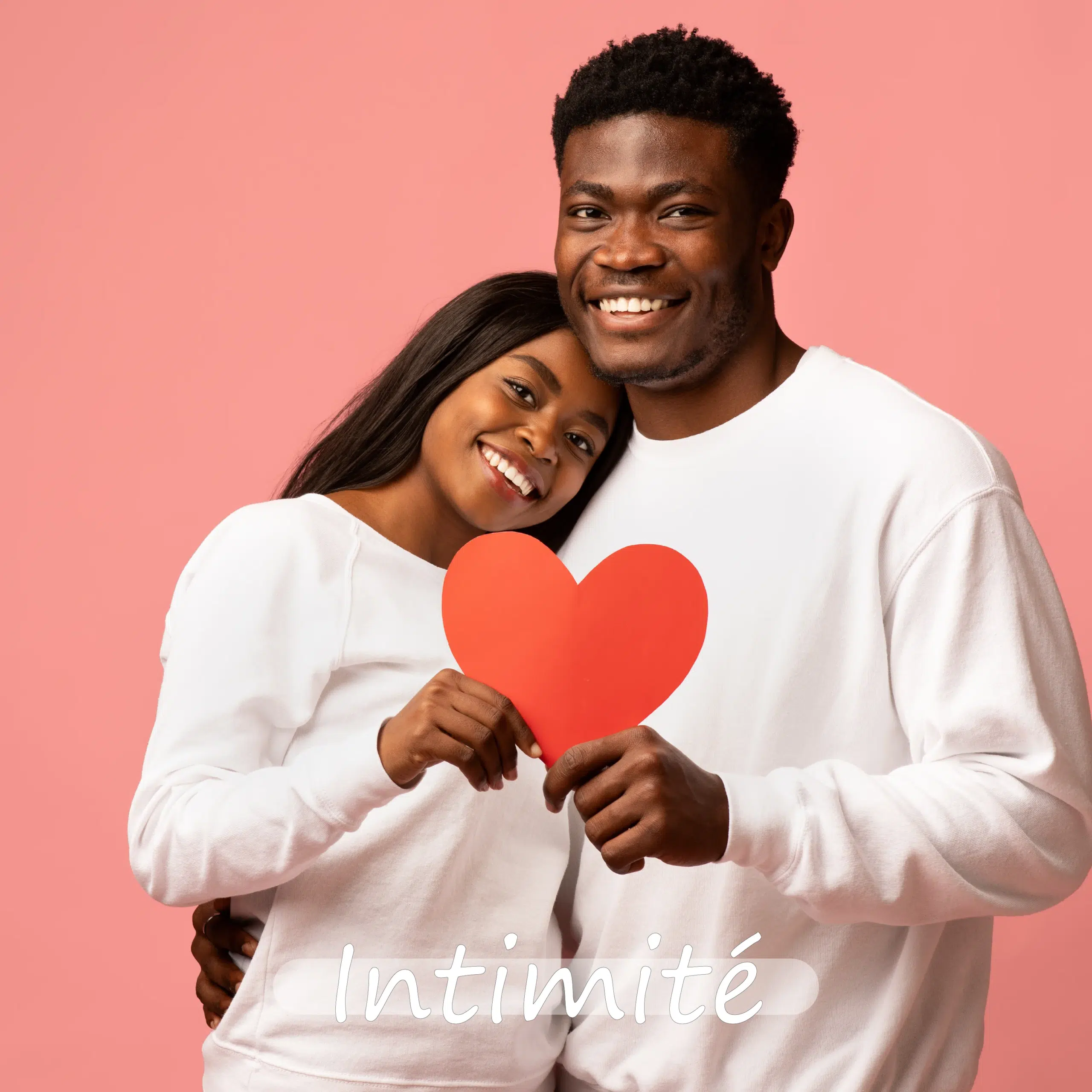 Un couple souriant, vêtu d'un pull blanc, tient ensemble un cœur en papier rouge sur un fond rose, rayonnant de chaleur et de connexion. Le mot "Intimité" apparaît en bas, illustrant l'esprit de tendresse d'Univers Cosmetix. Dakar