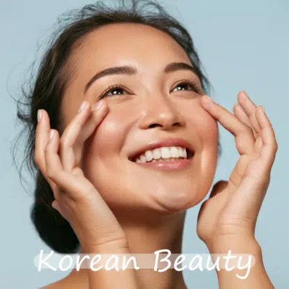Une femme souriante se touche doucement les joues avec les deux mains sur un fond bleu clair. Les mots "Korean Beauty" et "Univers Cosmetix" sont écrits en blanc au bas de l'image. Dakar