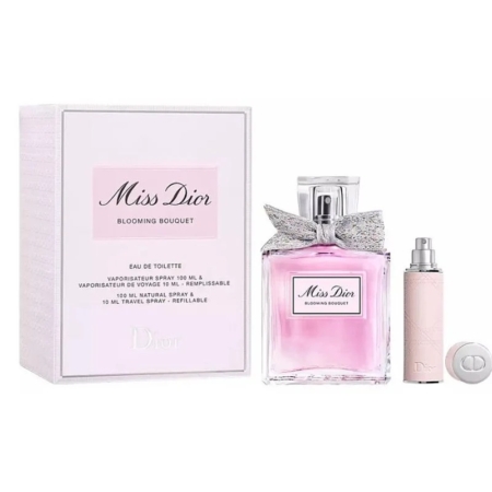 Coffret de l'Eau de Toilette Miss Dior Blooming Bouquet, comprenant le flacon de parfum rose avec un nœud argenté, un vaporisateur de voyage et un bouchon rond, tous placés à côté de l'emballage. Dakar