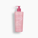 Un flacon rose de Bioderma Sensibio Gel moussant avec un distributeur à pompe, étiqueté comme un gel moussant nettoyant micellaire apaisant pour les peaux sensibles, 500 ml (16.7 fl oz). Dakar