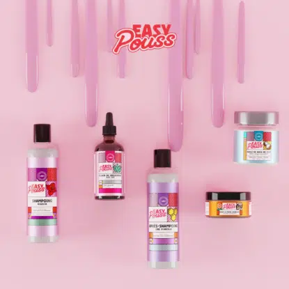 Cinq produits de soins capillaires Easy Pouss d'Univers Cosmetix sont disposés sur un fond rose avec des mèches roses brillantes et le logo Easy Pouss au-dessus d'eux. La gamme comprend des flacons, des pots et un compte-gouttes. Dakar