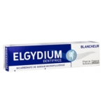 Une boîte de dentifrice Elgydium Blancheur avec un design bleu et blanc, comportant un logo de dent et étiqueté "Bicarbonate de Sodium Micropulvérisé" et "Pierre Fabre Oral Care". Dakar