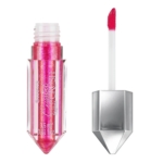 Un tube de Gloss à Lèvres Scintillant Essence Crystal Crush 01 Ruby Romance 3,5 ml, en rose scintillant, est présenté avec son bâton applicateur angulaire et le bouchon géométrique argenté à côté. Dakar