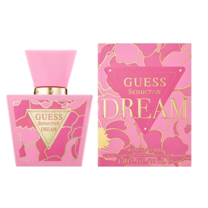 Un flacon rose du parfum GUESS Seductive Dream est présenté à côté de sa boîte florale rose et or assortie. Les deux présentent un lettrage et des accents de design audacieux en or. Le flacon est doté d'un large bouchon et d'une étiquette triangulaire. Dakar