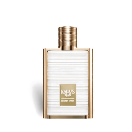 Flacon de parfum rectangulaire avec un corps blanc texturé, des accents dorés et un bouchon doré. L'étiquette sur le devant indique "KARUS SECRET MUSK" en lettres blanches et or. Dakar