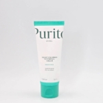 Un tube de 100 ml de Purito Crème Visage Hydratante au Panthénol et à l'Extrait de Bambou se tient debout sur un fond blanc uni. Le tube blanc aux accents sarcelle contient une crème hydratante pour le visage. Dakar