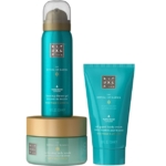 Trois produits de soin Ritual of Karma de couleur turquoise : un gel douche moussant dans un grand bidon, une crème fouettée pour le corps dans un tube et un gommage adoucissant pour le corps dans un pot rond, tous avec des couvercles dorés et un texte blanc. Dakar
