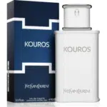 Un flacon d'eau de toilette Yves Saint Laurent Kouros se trouve à côté de son coffret bleu foncé et blanc, tous deux portant le nom de la marque et du produit. Le flacon est blanc avec un bouchon argenté et contient 100 ml. Dakar