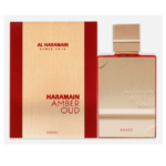 Un coffret or et rouge étiqueté "Al Haramain Amber Oud Rouge Perfumes Unisex 100ml" se trouve à côté d'un flacon or assorti avec un bouchon or ; tous deux présentent la marque et le nom du produit de manière élégante. Dakar