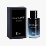 Un flacon de Dior Sauvage Eau de Parfum se trouve à côté de son coffret noir assorti, tous deux comportant un texte blanc sur un fond dégradé foncé. Dakar