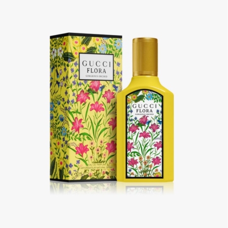 Un flacon jaune du parfum Gucci Flora Gorgeous Orchid se trouve à côté de sa boîte à motifs floraux assortie, tous deux décorés de fleurs roses vibrantes et de feuillage vert sur un fond jaune. Dakar