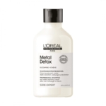 Une bouteille blanche de L'Oréal Professionnel Paris Metal Detox Professional Shampoo avec un bouchon noir, étiquetée pour une utilisation après une coloration, un balayage ou une décoloration sur le devant. La bouteille contient 300 ml (10.1 fl. oz.). Dakar