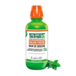Une bouteille verte de bain de bouche The Breath Co. avec un bouchon orange vif, étiquetée pour une haleine fraîche en français. Un brin de menthe se trouve à côté de la bouteille, indiquant l'arôme de menthe. Dakar