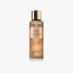 Une bouteille transparente de brume de parfum Victoria's Secret Bare Vanilla avec un bouchon doré et une étiquette pêche, contenant 250 ml (8,4 oz liq.) de produit, présentée sur un fond blanc. Dakar