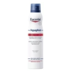 Une boîte blanche de Eucerin Aquaphor Body Ointment Spray avec un bouchon bleu et une étiquette bleue et rouge, conçue pour les peaux sèches et irritées. Le texte sur le flacon indique qu'il accélère la régénération de la peau. Dakar