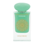 Flacon de parfum transparent avec un bouchon et une étiquette vert pastel, avec des motifs décoratifs dorés et le texte "PISTACHIO" et "BY GULF ORCHID". Dakar