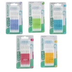 Cinq paquets de brosses interdentaires GUM Bi-Direction de différentes couleurs : bleu, vert, turquoise, rose et jaune. Chaque paquet contient six brosses dans un emballage en plastique transparent avec des poignées blanches. Dakar