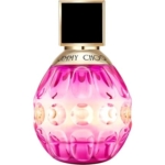 Un flacon de parfum rose et or à facettes avec un bouchon noir carré et "Jimmy Choo" écrit sur la collerette dorée près du sommet. Le flacon a un design dégradé et reflète la lumière. Dakar