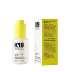 Un flacon de 30 ml de K18 Biomimetic Hairscience Molecular Repair Hair Oil est présenté à côté de sa boîte jaune et blanche, qui affiche des informations sur le produit en anglais et en français. Dakar