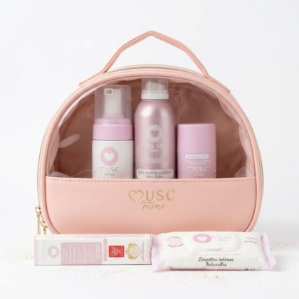 Une trousse de toilette rose à l'avant transparent présente quatre produits de soins personnels rose pastel et un paquet de lingettes, tous étiquetés "Musc Intime". La trousse est munie d'une poignée et d'une fermeture éclair dorée. Dakar