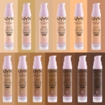 Quinze flacons de NYX Bare With Me Concealer Serum sont alignés devant des arrière-plans correspondant à chaque nuance, allant des teints très clairs aux teints profonds. Dakar