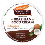 Couvercle d'un récipient rond contenant la crème brésilienne à l'huile de coco Palmer's Coconut Oil Formula. Le texte indique qu'il s'agit d'une crème fouettée pour les fesses, le buste et le corps, contenant de la vitamine E et promettant des résultats visibles et raffermissants en seulement 2 semaines, avec des images de noix de coco. Dakar