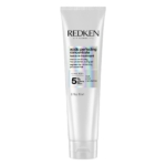 Tube blanc de Redken Acidic Perfecting Concentrate Leave-In Treatment avec de l'acide citrique, concentration de 5%, pour les cheveux traités. Le tube est de 150 ml (5.1 fl oz) et comporte un texte noir et holographique. Dakar