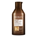 Un flacon marron de l'après-shampoing Redken All Soft Mega Curls avec un bouchon noir, comportant un texte blanc et or décrivant sa formule nourrissante pour les boucles et les spires très sèches. Dakar