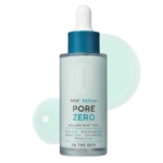 Un flacon compte-gouttes bleu et transparent étiqueté "BHA+ Serum Pore Zero" de Be the Skin, avec des gouttes de sérum en arrière-plan. Le texte met en évidence les avantages de ce produit, notamment la réduction des pores, des points noirs, du sébum et des comédons. Dakar