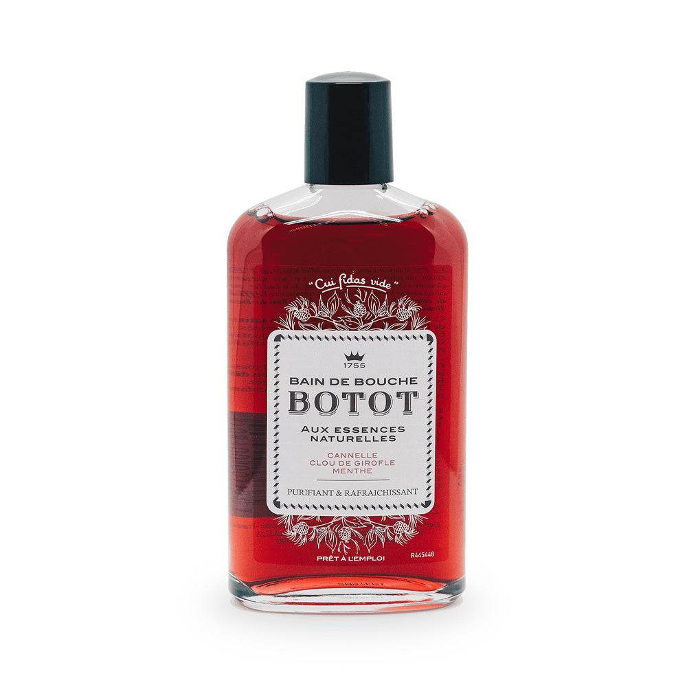 Une bouteille de bain de bouche Botot avec un liquide rouge à l'intérieur, un bouchon noir et une étiquette blanche portant un texte en français décrivant ses essences naturelles et ses propriétés purifiantes et rafraîchissantes. Dakar