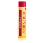 Un tube de baume à lèvres à la grenade Burt's Bees, debout, avec un corps jaune, un bouchon rouge et une étiquette rouge indiquant le nom et le parfum du produit. Dakar