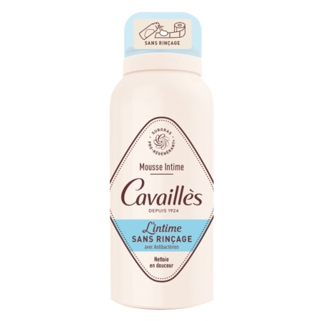 Un flacon de Cavaillès Mousse Intime L'intime Sans Rinçage, une mousse antibactérienne de nettoyage intime sans rinçage, avec une étiquette blanche et bleu clair et un bouchon beige avec une illustration. Dakar