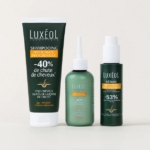 Trois produits de soins capillaires Luxéol sont présentés : un shampooing anti-chute en tube, un après-shampooing en flacon compte-gouttes et un sérum en flacon-pompe, tous avec un emballage vert et des étiquettes blanches et orange. Dakar