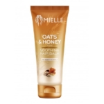 Un tube de baume capillaire Mielle Avoine & Miel pour cuir chevelu sensible, avec un motif dégradé brun et or et des images d'avoine et de miel près du fond. Dakar