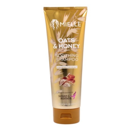 Un tube doré de Mielle Organics Shampooing Apaisant A L'Avoine Et Au Miel 237ml pour cuir chevelu sensible, avec des graphiques d'avoine et de miel, le logo de soutien de Susan G. Komen, inspiré de leur shampooing à la grenade et au miel. Dakar