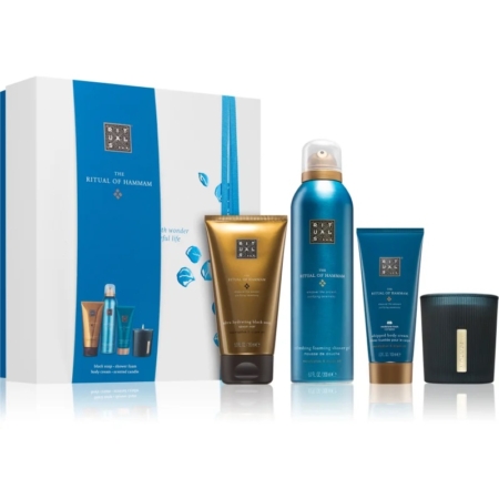 Un coffret Rituals, The Ritual of Hammam, comprenant quatre produits : un tube doré, un vaporisateur bleu, un tube bleu et une bougie noire, placés à côté d'une boîte blanche et bleue avec des illustrations de gouttes d'eau. Dakar