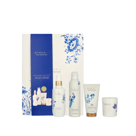 Un coffret cadeau Rituals composé de quatre articles : une boîte florale blanche et bleue, un flacon blanc, une canette blanche, un tube blanc et une petite bougie blanche, tous ornés de motifs floraux bleus. Dakar