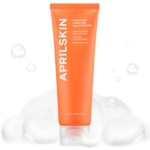 Un tube orange de la mousse nettoyante clarifiante Carrotene d'AprilSkin se dresse, entouré de mousse blanche, à côté de la Crème clarifiante et équilibrante pour peaux à imperfections d'AprilSkin (60 ml) ; les deux produits présentent leurs caractéristiques sur le devant. Dakar