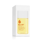 Un flacon de 25 ml de l'huile de soin Bio-Oil devant son emballage blanc. Le flacon contient un liquide jaune et comporte un texte et un logo de couleur orange, avec des inscriptions en anglais et en arabe sur l'étiquette. Dakar