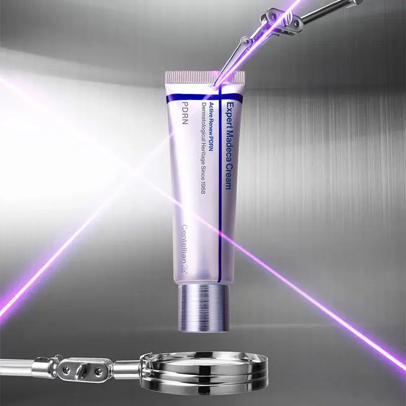 Un tube de Dr Althea Reju 5000 Crème Hydratante Apaisante 20ml (Copie) est présenté sur un fond métallique, rehaussé de lasers violets et d'instruments futuristes, faisant écho à l'aspect moderne de ses publicités. Dakar