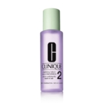 Un flacon de 200 ml de la lotion exfoliante « 3 Temps » de Clinique pour peaux sèches à mixtes, contenant un liquide violet, muni d'un bouchon vert clair et d'une étiquette en noir et blanc sur un flacon transparent. Dakar
