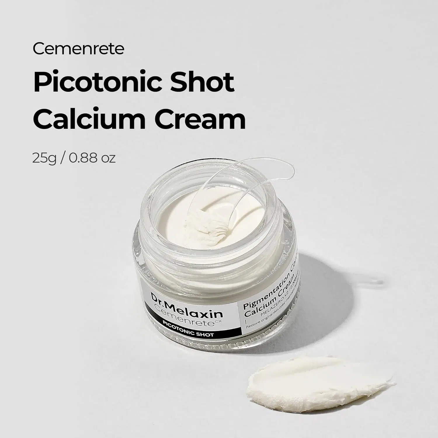 Un pot ouvert de « Medicube Crème Hydratante Clarifiante Capsule AGE-R Glutathion Glow 50 ml (Copie) », contenant une spatule transparente, repose sur une surface blanche ; un peu de crème est étalée à côté. Le nom et les détails du produit sont visibles sur l'image. Dakar